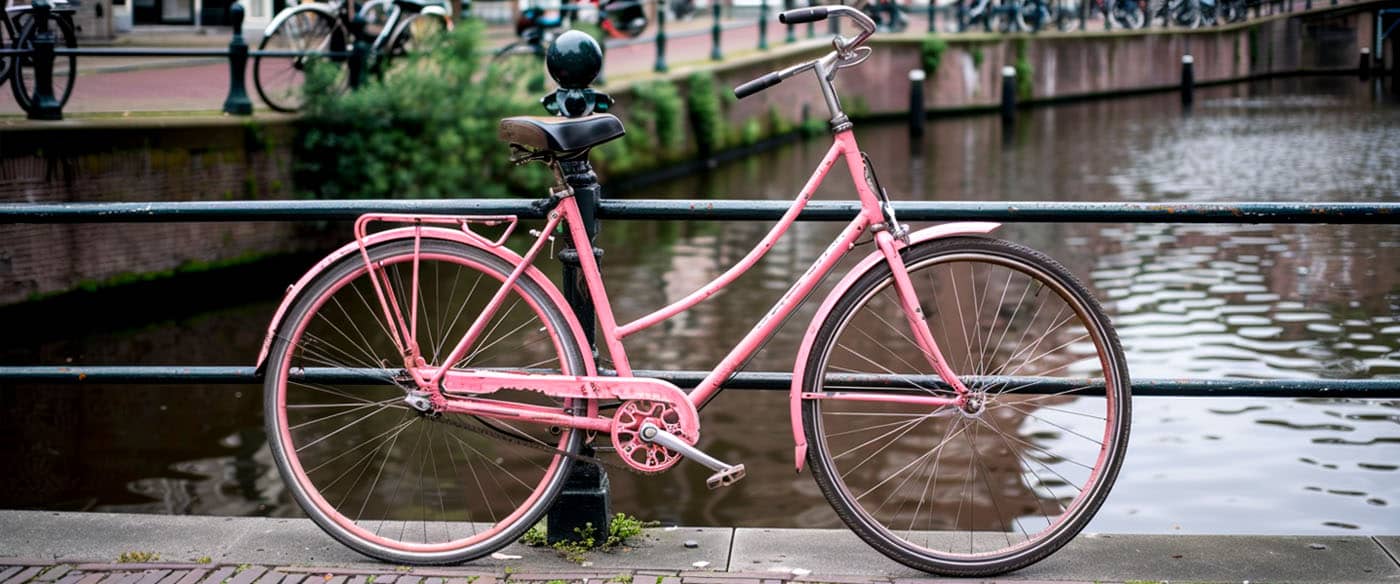 Roze fiets aan een gracht in een stad